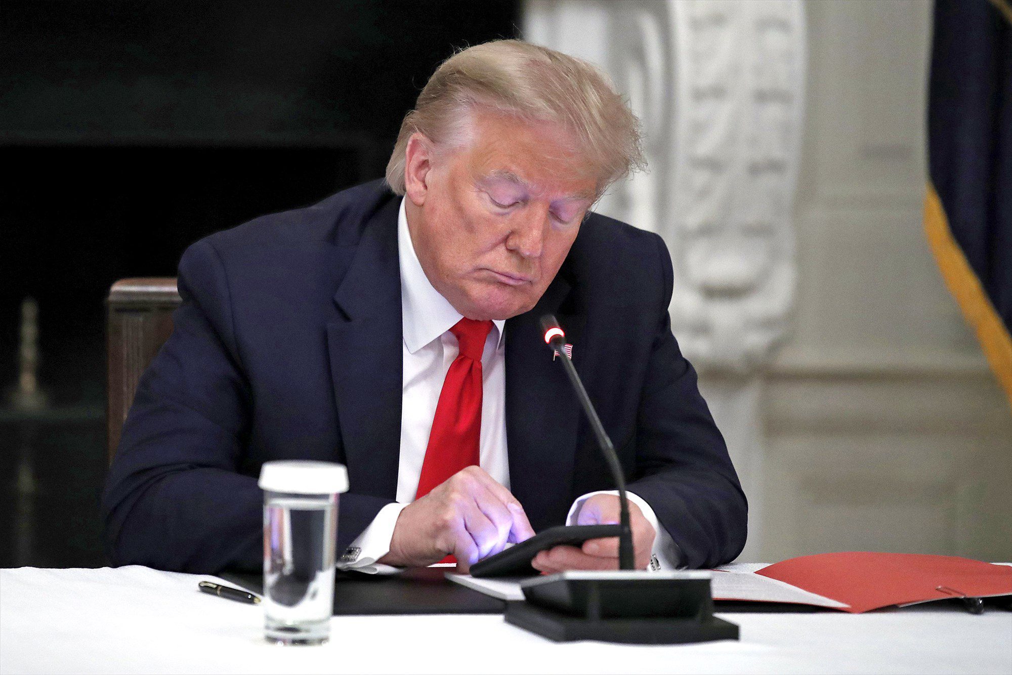 Donald Trump looks at his mobile phone